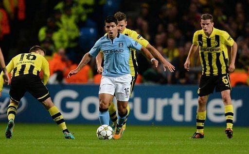 Manchester City's Sergio Aguero (C) looks for a way through the Dortmund defence